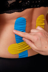 Kinesiology therapeutic taping of lumbar spine of young woman. - 726380171