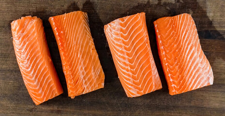 Salmon Fresh Raw Fillet on wooden board banner. Homemade cooking sliced salmon background, serving food for restaurant, menu, advert or package, close up, selective focus