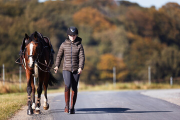Obraz premium Girl rider goes riding with her horse ready to ride.