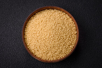 Wheat porridge couscous grains on a dark concrete background