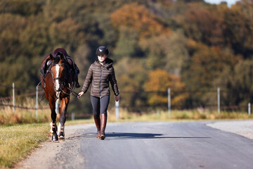 Obraz premium Girl rider goes riding with her horse ready to ride.