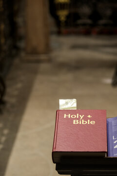 The Holy Bible in a church, in the right-hand corner of the image. A bookmark indicates the prayer of the day.