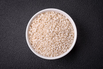 Large grains of uncooked white rice in a ceramic bowl
