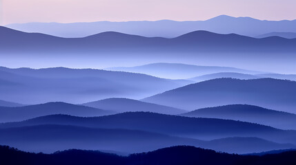 Landscape with blue misty silhouettes of mountains at sunrise