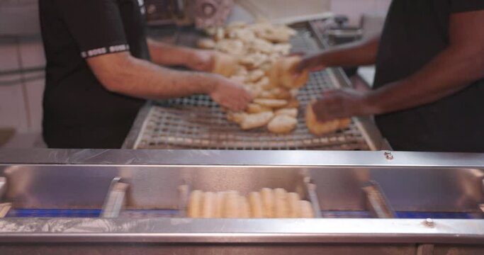 Worker packaging freshly baked pitas in plastic bag,  baking factory