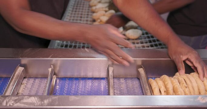 Worker packaging freshly baked pitas in plastic bag,  baking factory