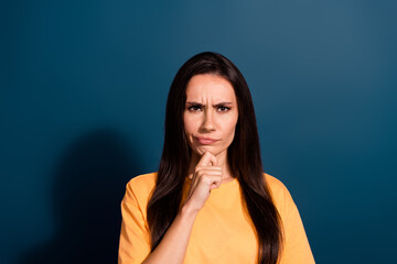 Portrait of suspicious woman with straight hairdo wear stylish t-shirt staring finger on chin isolated on dark blue color background