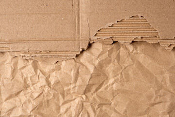 Torn sheet of corrugated cardboard and crumpled kraft paper