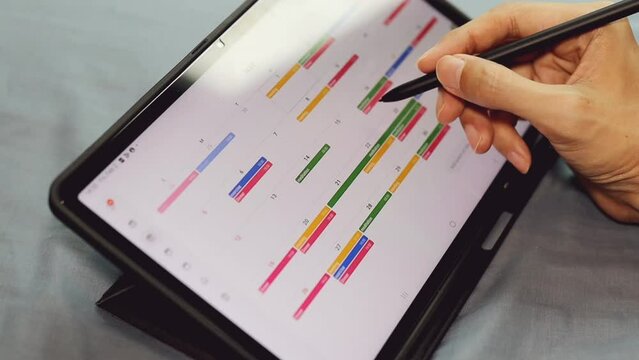 man using weekly planner on digital tablet.