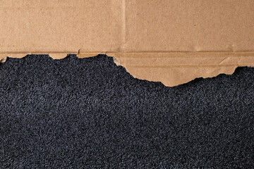 Torn sheet of corrugated cardboard and black sponge texture