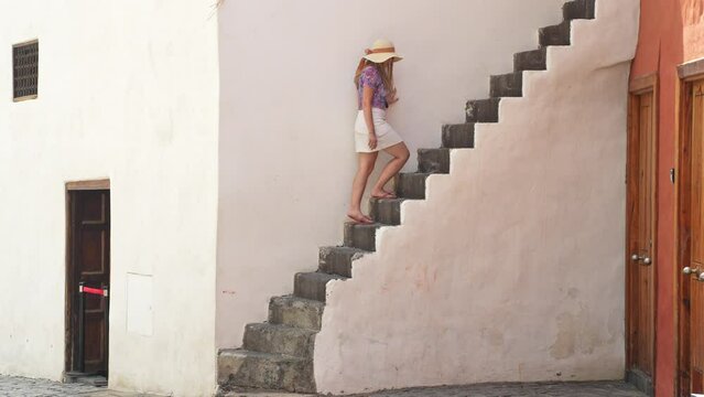 Attractive woman walking up stairs in Puerto de la Cruz, side view