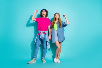 Full body photo of two youth teenagers fists up holding arms together achievement in relationships...