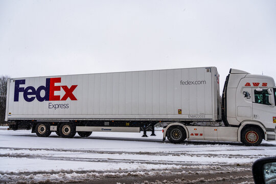 FedEx truck trailer with large lettering on the trailer at a motorway parking lot in the snow