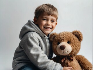 Smiling young boy with a cute adorable teddy bear on plain white background from Generative AI