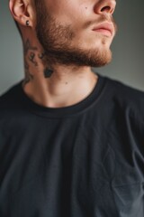 Fototapeta premium A close-up portrait of a man with a tattoo on his neck. This image can be used to depict individuality, rebellion, or modern fashion trends.