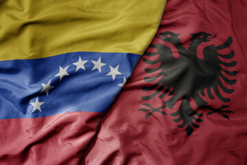 big waving national colorful flag of albania and national flag of venezuela . macro
