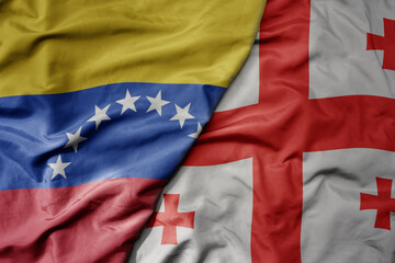 big waving national colorful flag of georgia and national flag of venezuela . macro