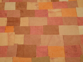 Handmade background in patchwork style with cotton fabric elements in pink and brown tones,...