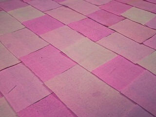 Handmade background in patchwork style with cotton fabric elements in pink tones
