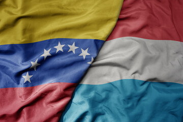 Fototapeta premium big waving national colorful flag of luxembourg and national flag of venezuela . macro