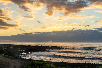 sunset with water refelction over the sea from the coast of the pacific on big island in hawaii