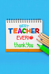 Childish lettering for Teachers' Day on notebook or scrapbook. Appreciation of teachers top view flat lay concept. Colored paper, multi-coloured letters, supplies