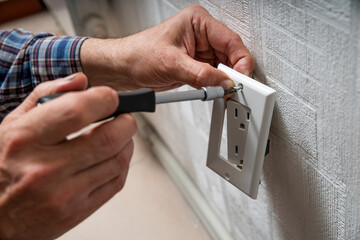 Installation or repair of electrical outlet socket box within the wall. Serviceman or repairman...