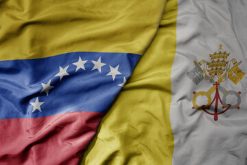 big waving national colorful flag of vatican city and national flag of venezuela . macro
