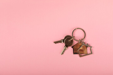 Keychain in the shape of a house with a key ring on background. Concepts for real estate and moving...