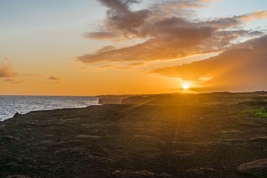 full moon during sunset over the cliffs of the volcanos on the coast of the pacific on big island in hawaii