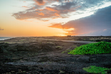 sunset over the volcanos with green plants on big island in hawaii