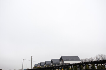 Fototapeta premium Parking for cars from iron profiles and roofs, on a city street on a cloudy day. Image for your design or creative illustrations.