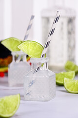 Classic alcoholic cocktail Margarita. Served in mini bottles with salt and lime. An original idea for a buffet event.