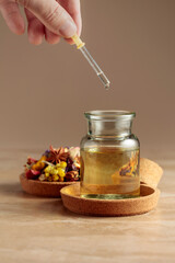 Dropping essential oil or herbal tincture into a glass bottle.