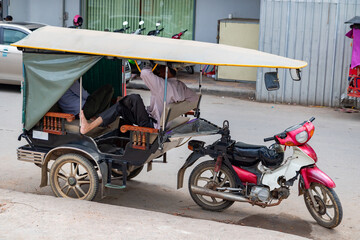 Tricycle taxi drivers have a break in the streets of Phnom Penh, Cambodia