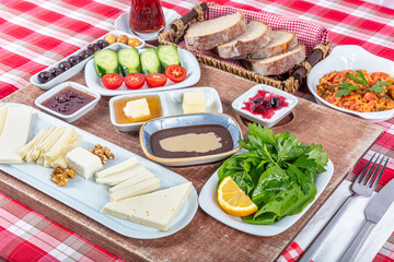 Turkish Cuisine Breakfast Plate. Traditional delicious Turkish breakfast, food concept photo. Rich variety of cheese, tomato, cucumber, egg, jam on wooden background.