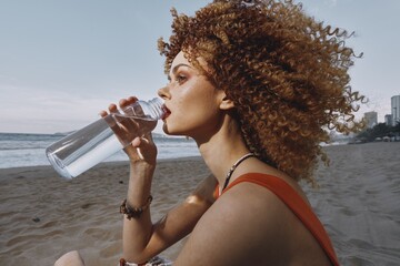 Thirsty Woman Drinking Cold Water on a Sunny Beach