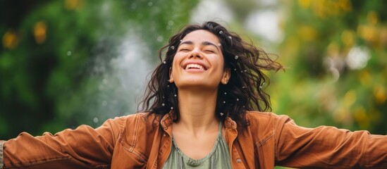 Smiling Hispanic woman with open arms, happily embracing joy.