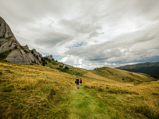 Fototapeta premium Tourists hiking on beautiful alpine mountain in Transylvania