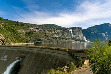 A beautiful panoramic view of the O’Shaughnessy Dam Aqueduct and Hetch Hetchy Reservoir in Yosemite NP. The Tueeulala and Wapama Falls are in the distance. 