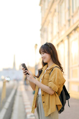 Traveler asian woman in her 30s using smartphone for navigation destination on the urban street at...