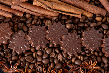 Food background. Coffee beans, cinnamon sticks, anise stars and chocolate candies top view.