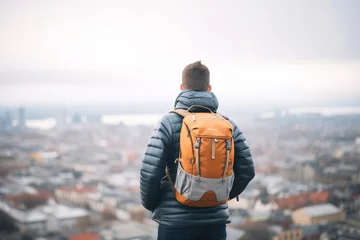 Deurstickers man with backpack overlooking city from high viewpoint © primopiano