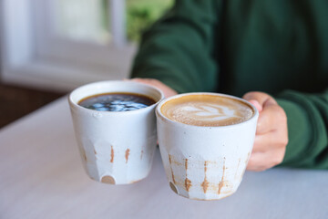 Closeup image of a woman holding and serving two cups of hot coffee