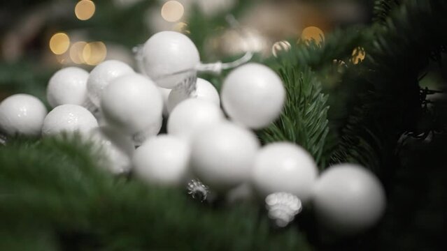Close-up of fir branches with falling Christmas baubles
