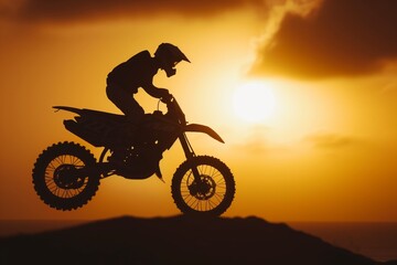 Obraz na płótnie Canvas moto jumper silhouetted by setting sun