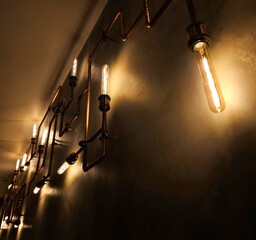 Modern led light made from water pipes. Rustic design, stucco wall with light bulbs and pipes....