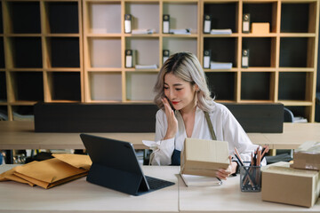 Fototapeta na wymiar Small business entrepreneur SME freelance woman working at home office, BOX,tablet and laptop online, marketing, packaging, delivery, e-commerce concept..