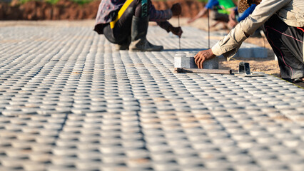 Installing paving blocks concept. Diligent man engages in outdoor construction work, laboriously...