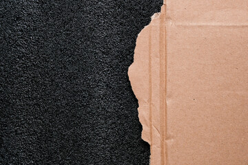 Torn sheet of cardboard with black protective polyurethane foam